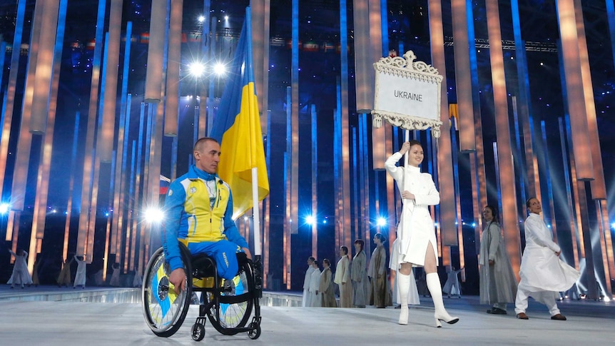 Ukraine's flag-bearer Mykhailo Tkachenko arrives in the Olympic Stadium