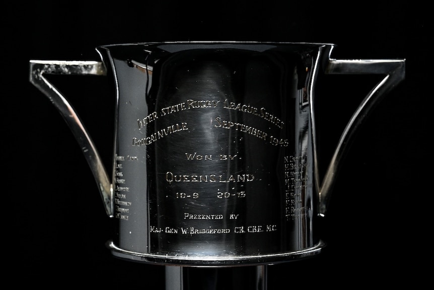 photo of polished trophy engraved with words "Won by Queensland" with scores and players' names