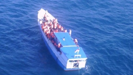 An aerial photograph of a boat carrying asylum seekers in the ocean.