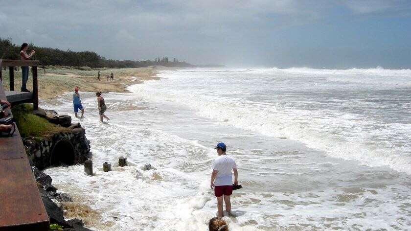 Holiday-makers stand in the storm surge