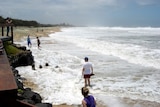 Holiday-makers stand in the storm surge