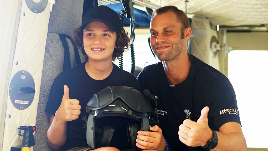 12yo Connor Creagh in a LifeFlight Rescue helicopter with one of the crew that aided him after he was crushed by a tree in 2018