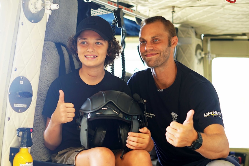 12yo Connor Creagh in a LifeFlight Rescue helicopter with one of the crew that aided him after he was crushed by a tree in 2018