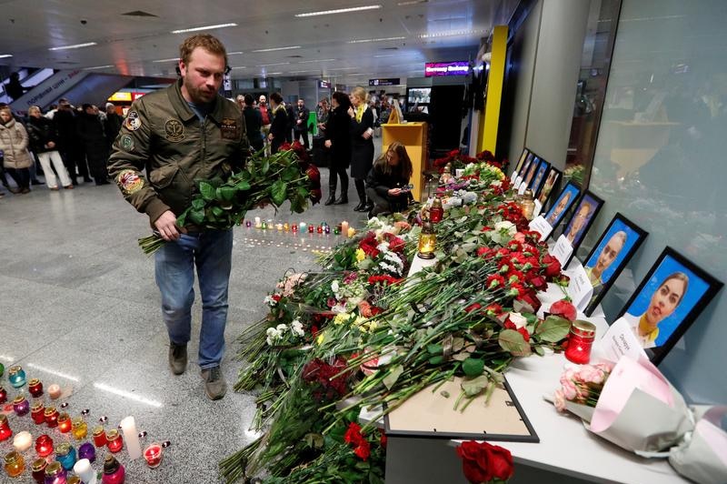 A man places flowers to commemorate passengers and flight crew members killed in the crash.