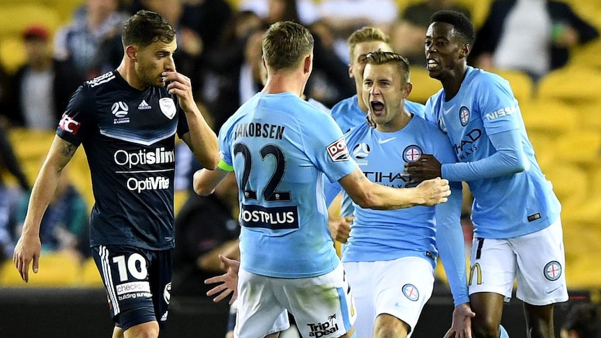 Marcin Budzinski screams out as he is hugged by Melbourne City teammates.