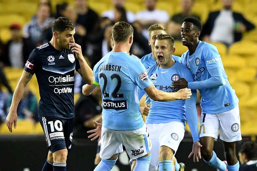 Marcin Budzinski screams out as he is hugged by Melbourne City teammates.