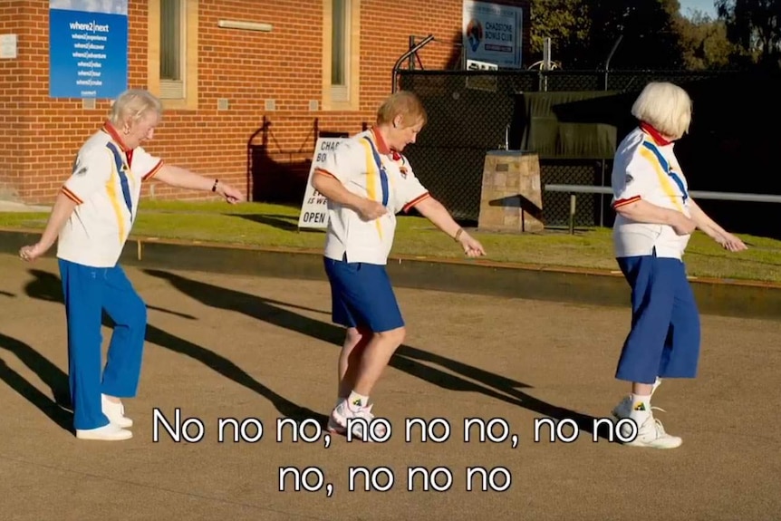 Three bowling ladies hold their fists out as they do the Single Ladies dance.