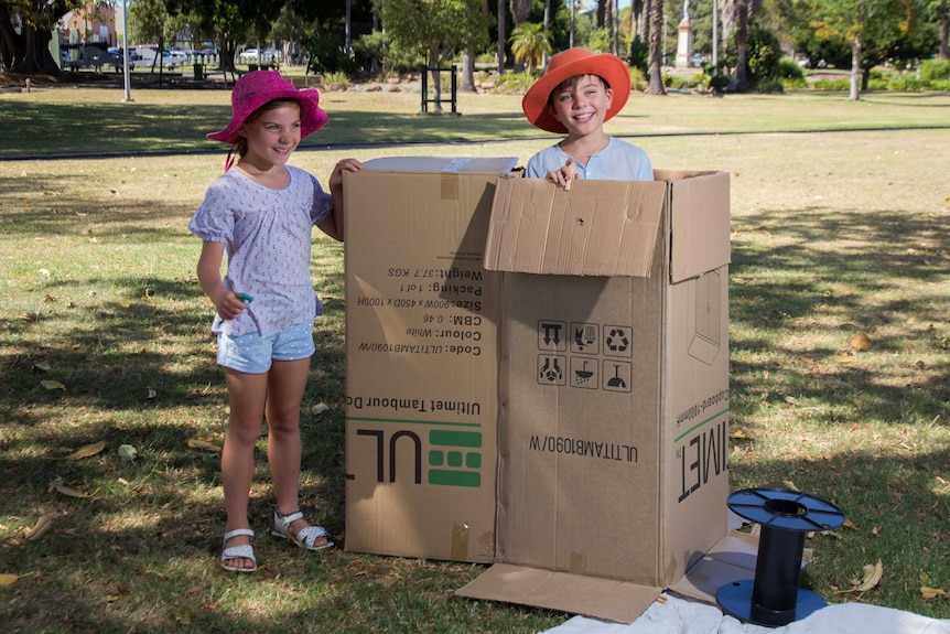 Marina and Jasper Chamberlain play with a box.