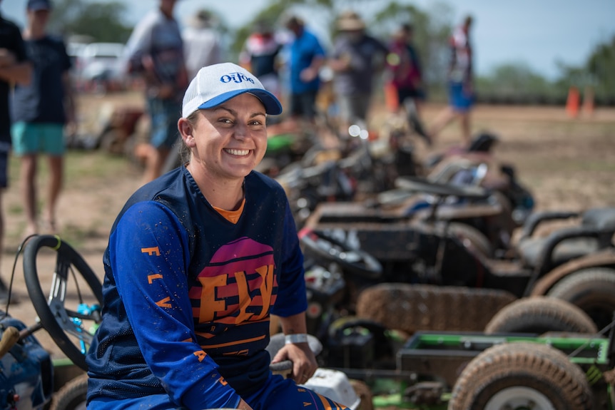 Jazmin Clark sits on her racing lawn mower.