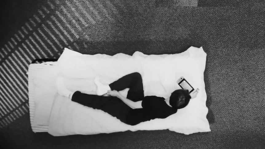 Overhead view of youth in prison cell.