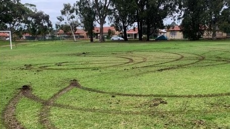 Tyre marks left in the turf of a soccer oval.