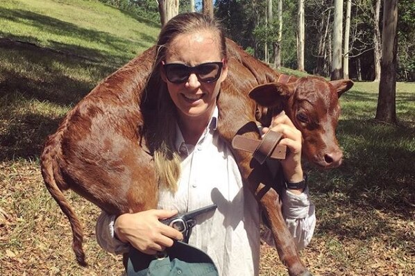 Jo Joyce with a calf wrapped around her neck