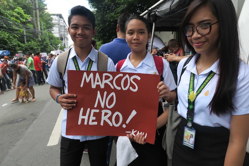 University students (from left) Charlie, Sophie and Katherine rally against Marocos burial outside the Supreme Court in Manila.
