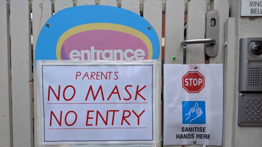 A sign saying 'no mask no entry' on a gate.