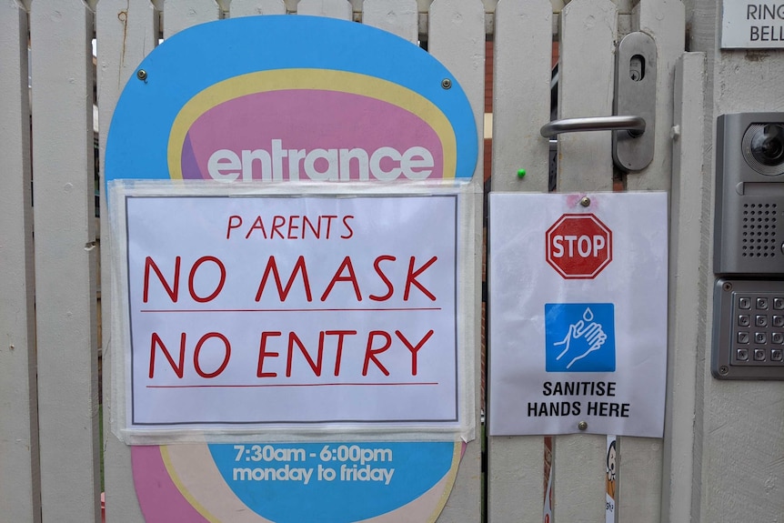 A sign saying 'no mask no entry' on a gate.