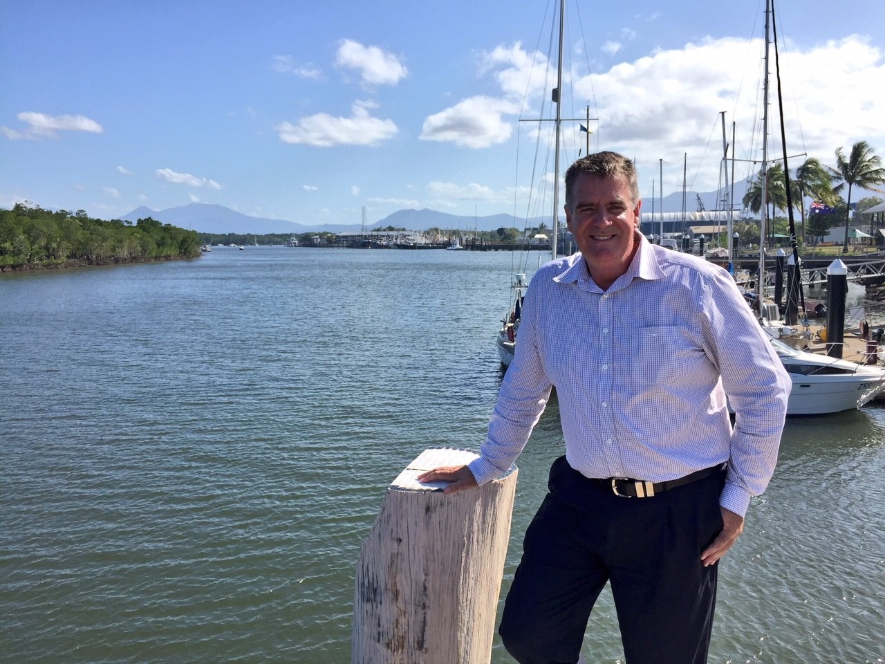 Man in shirt standing beside a creek.