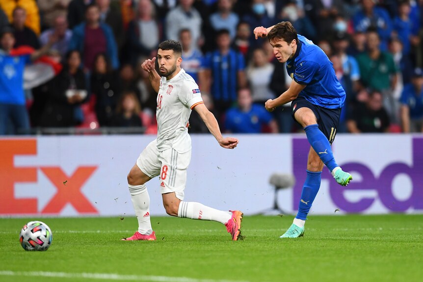 Un delantero italiano dobla la pierna alrededor del balón al anotar en las semifinales de la Eurocopa 2020