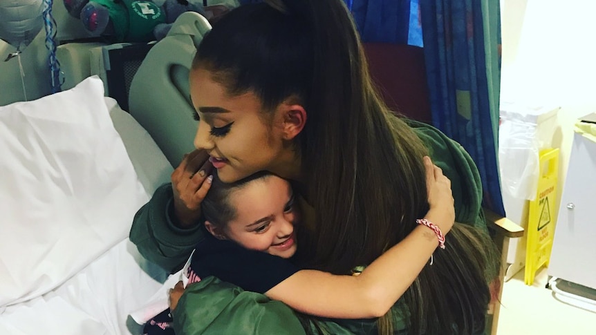 Ariana Grande hugs young fan Lily Harrison at The Royal Manchester Children's Hospital.