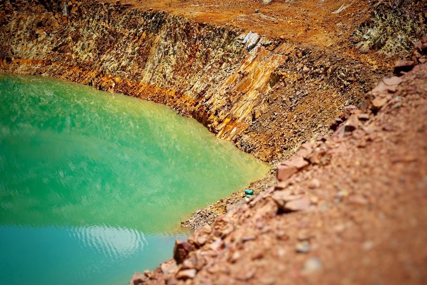 Murky, acidic water can be seen in an open cut pit at Mt Todd.