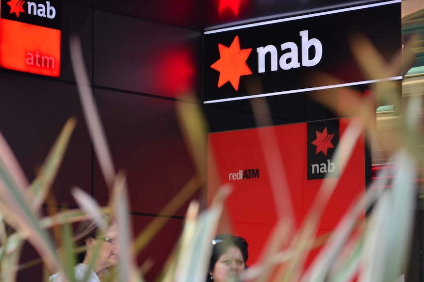 People walk past a NAB ATM in Brisbane.