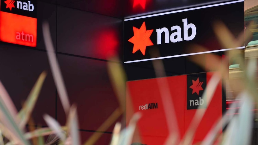 People walk past a NAB ATM in Brisbane.