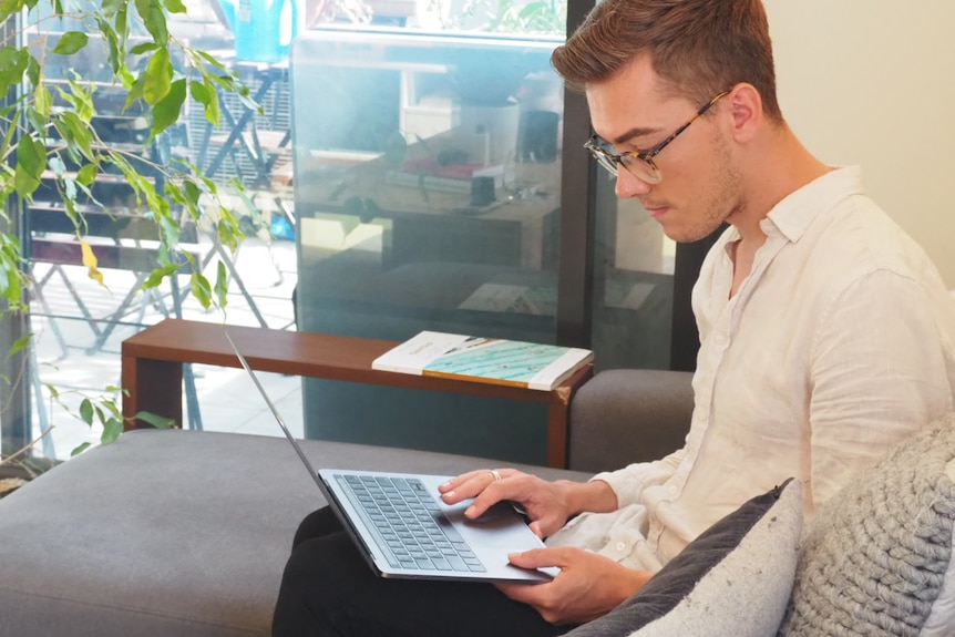 Glenn Turnham uses his laptop in his living room.