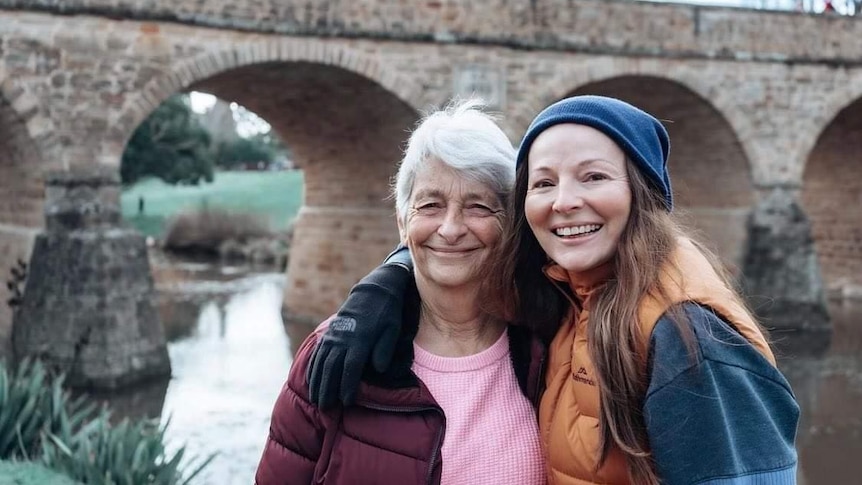 Naomi Hutchings with her mum Dianne stand in front of a bridge
