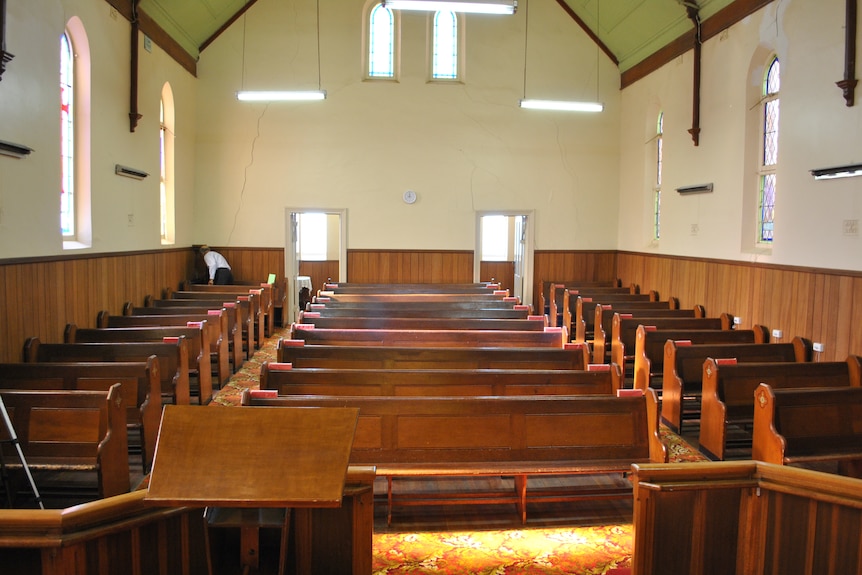 An old church hall with pews. 