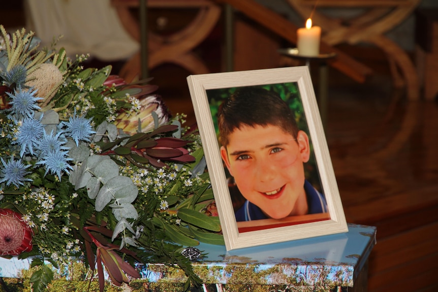 A young boy's photo sits atop of coffin.
