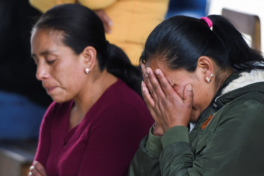 Yolanda Olivares reacts during a mass for her sons Jair, 19, Yovani, 16, and her nephew Misael, 16.