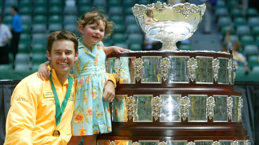 Australia's doubles player Todd Woodbridge and daughter Zara pose with Davis Cup trophy in 2003.