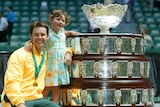 Australia's doubles player Todd Woodbridge and daughter Zara pose with Davis Cup trophy in 2003.