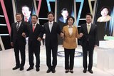 Five South Korean presidential candidates pose, holding hands, in a TV studio before a debate.