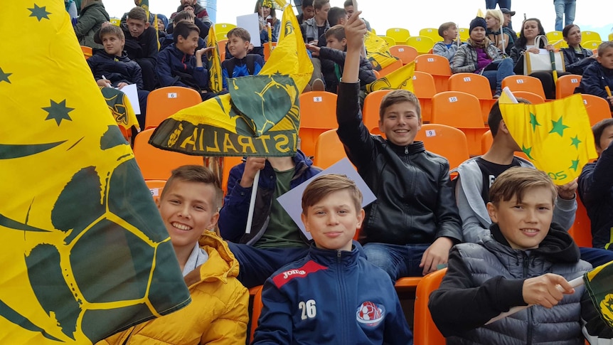 Schoolchildren waving flags at a Socceroos training session in Kazan, Russia on June 11, 2018.
