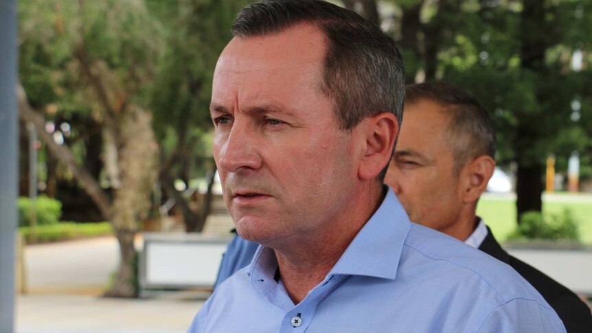 A head and shoulders shot of WA Premier Mark McGowan speaking outdoors wearing a blue collared shirt.