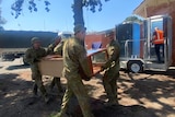 ADF personnel helping with recovery effort, with portable toilet in the background.