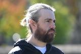 Co-CEO of Atlassian Mike Cannon-Brookes attends a press conference looking to the side 