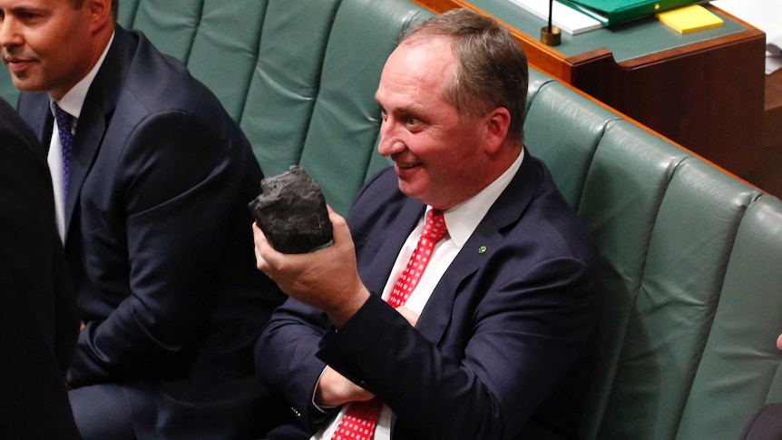 Barnaby Joyce holds a lump of coal while sitting on the frontbench in Parliament.