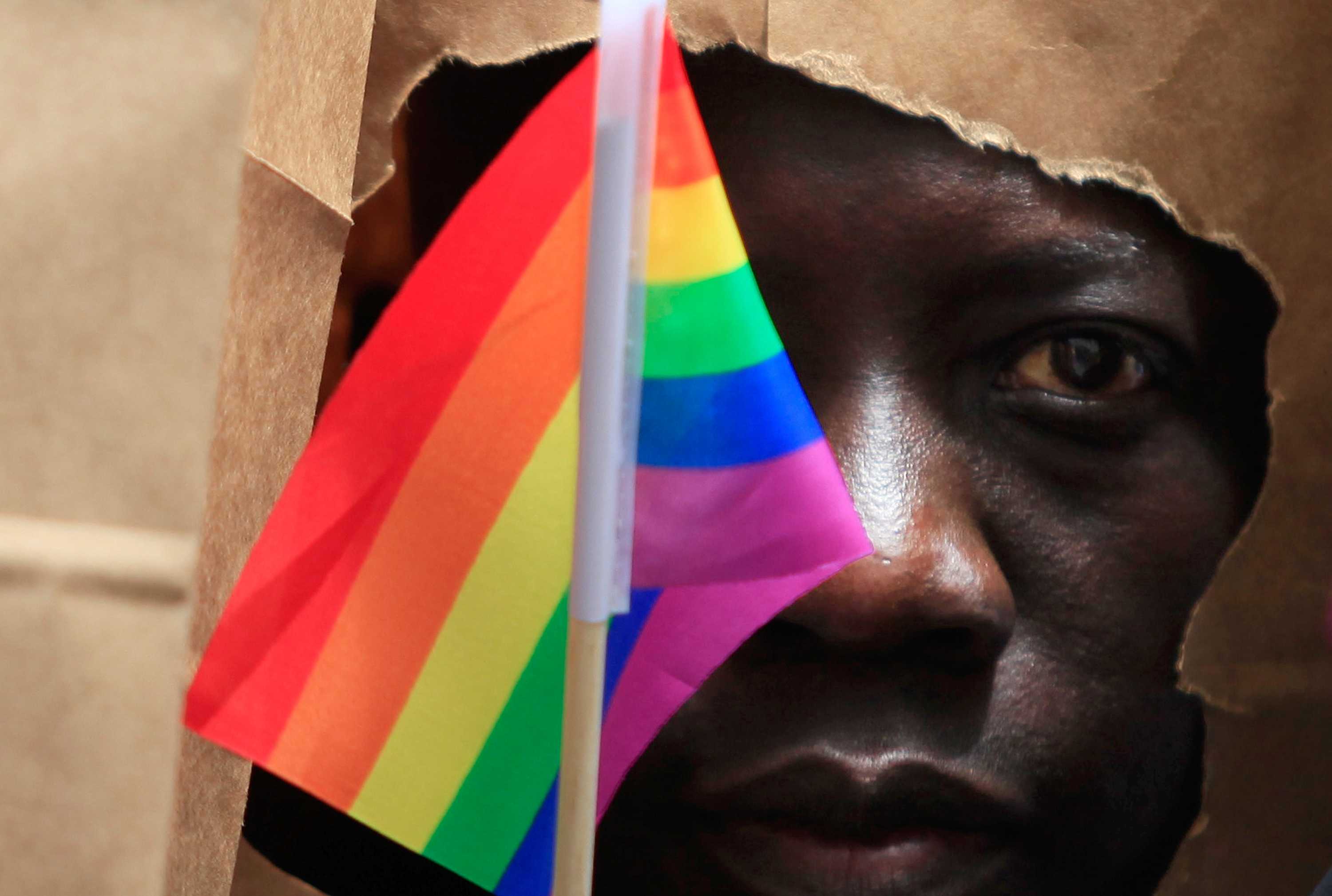An asylum seeker from Uganda covers his face with a paper bag in order to protect his identity at a gay pride parade in Boston.