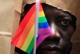 An asylum seeker from Uganda covers his face with a paper bag in order to protect his identity at a gay pride parade in Boston.
