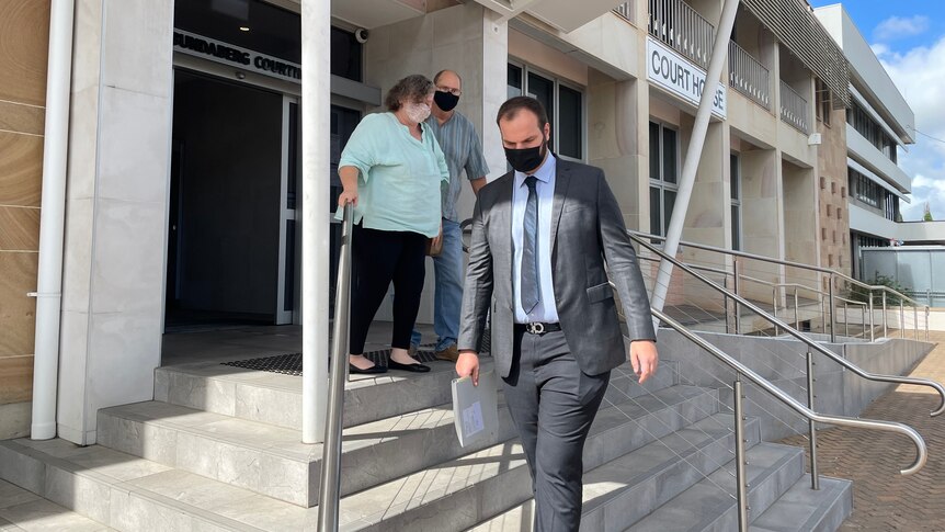 three people walk down steps, exiting the Bundaberg court house 