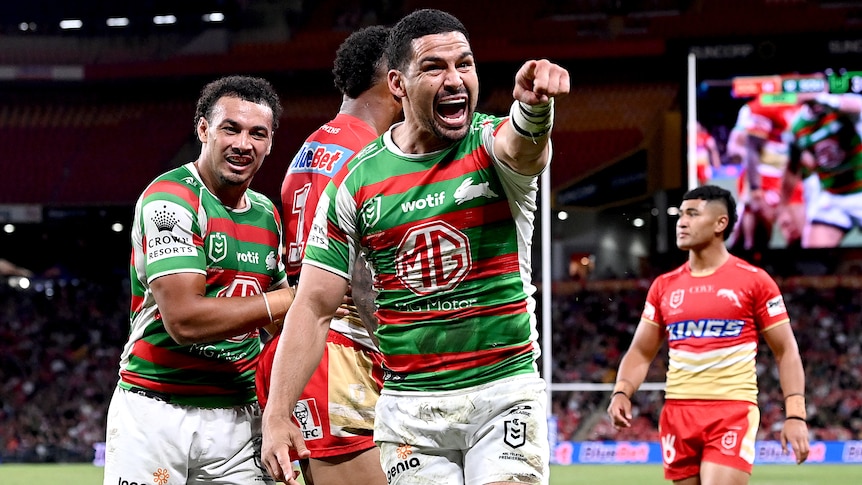A South Sydney NRL player points a finger on his left hand as he celebrates a try against the Dolphins.