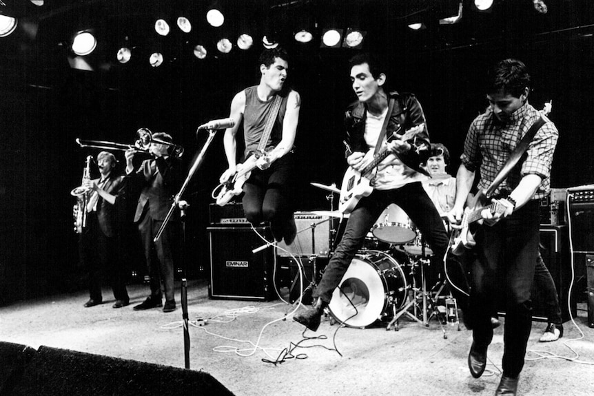 Paul Kelly and fellow guitar players jump on stage mid-set