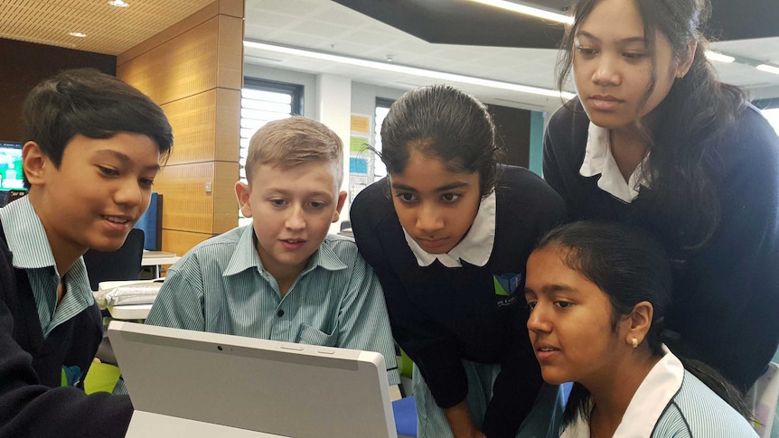 Students look at a laptop screen.