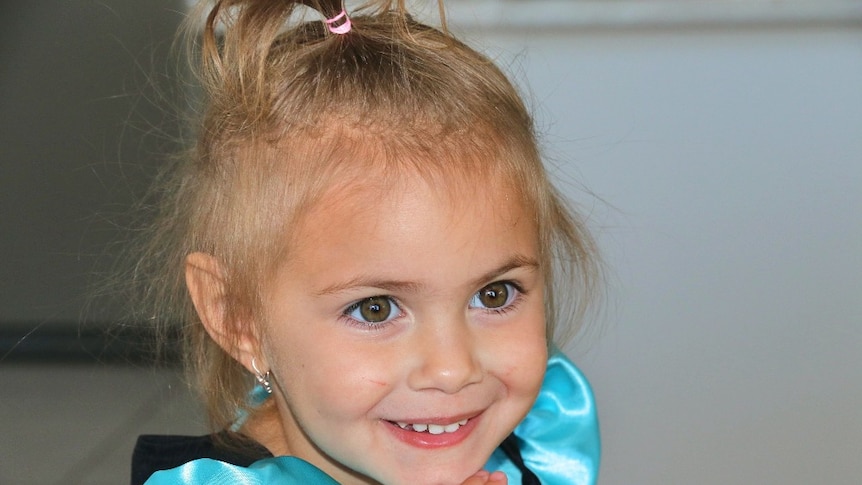 A close up on the face of a smiling young girl.