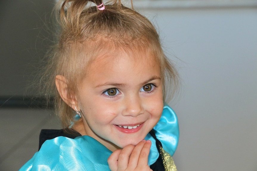 A close up on the face of a smiling young girl.