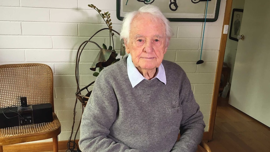 Dr Neil Davey sits at a table in him home.