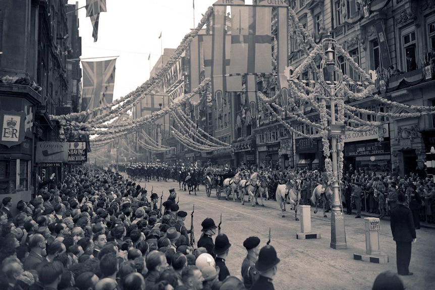 A black and white photo shows crowds in the streets for Elizabeth's coronation in 1953.