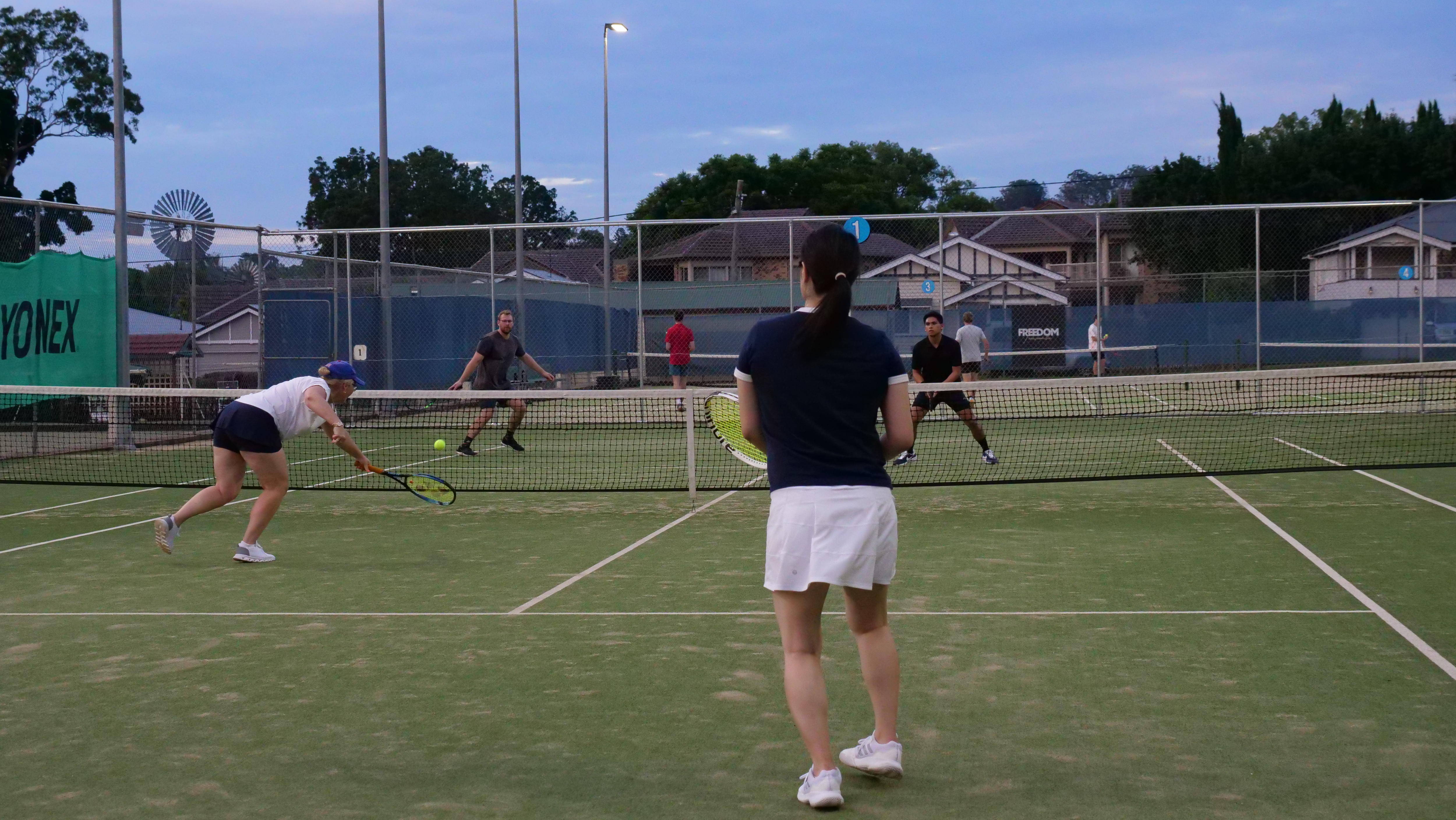 un partido de dobles en el que dos mujeres juegan contra dos hombres