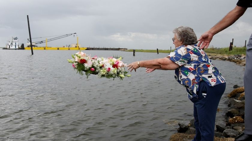 Cecile Robin tosses a wreath in the water during a memorial for victims of Hurricane Katrina.